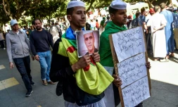 Des Algériens manifestent, brandissant le drapeau amazigh et un portrait du militant des droits humains, Kamel Eddine Fekhar, à Alger le 31 mai 2019