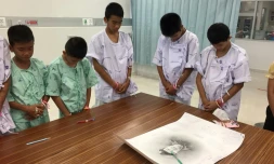 Photo prise le 14 juillet et diffusée le 15 juillet par le ministère de la Santé montre des jeunes footballeurs rescapés d'une grotte en Thaïlande avec un portrait du plongeur mort à l'hôpital de Chiang Rai Prachanukroh