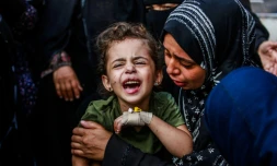 Une fillette palestinienne blessée est réconfortée par une femme à l'hÎpital des martyrs d'Al-Aqsa à Deir el-Balah dans le centre de Gaza, le 28 juin 2024
