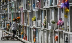 Une femme décore la tombe d'un proche avant le "Jour des morts" au cimetière de Nezahualcoyotl, le 28 octobre 2020 au Mexique