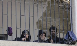 Des civils syriens rassemblés dans une école à Adra, une localité sous contrôle du régime après leur fuite des secteurs rebelles de la Ghouta orientale devant la progression des forces prorégime, le 16 mars 2018