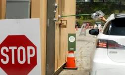 Un automobiliste reçoit un kit de prélèvement pour un test au coronavirus, le 25 juin 2020 à Los Angeles