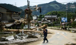 Un homme passe devant des décombres aprÚs des pluies torrentielles et des inondations dans le village de Kuma au Japon, le 8 juillet 2020