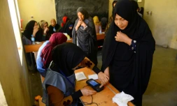 Une employée électorale enregistre l'empreinte biométrique d'une votante lors des législatives, le 20 octobre 2018 à Hérat, en Afghanistan
