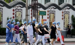Du personnel médical arrive le 16 juin 2020 dans un centre de dépistage du coronavirus pour les personnes habitant prÚs du marché de Xinfadi à Pékin ou s'y étant rendues. Un nouveau foyer de la maladie est apparu dans ce marché alimentaire de la capitale chinoise.