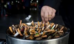 Un homme écrase une cigarette dans un cendrier dans une gare à Shanghai, le 28 février 2017 en Chine