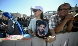 Un fidèle tient un portrait du bienheureux italien Carlo Acutis à la veille de sa canonisation, lors d'une audience jubilaire sur la place Saint-Pierre au Vatican le 6 septembre 2025