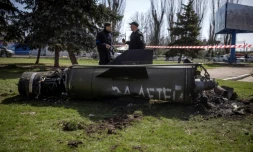 Des policiers ukrainiens devant les débris d'un missile sur lequel est écrit en russe "pour nos enfants" prÚs de la gare de Kramatorsk, cible d'une attaque qui a fait 35 morts, le 8 avril 2022 dans la région du Donbass, dans l'est de l'Ukraine