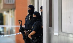 La police catalane monte la garde près d'un immmeuble où vivait un homme qui a attaqué un commissariat à Cornella près de Barcelone, le 20 août 2018