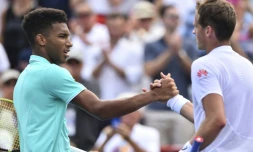 Le Canadien Félix Auger-Aliassime (g) serre la main de son compatriote Vasek Pospisil après l'avoir battu au 1e tour du Masters 1000 de Montréal, le 6 août 2019