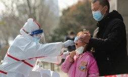 Un membre du personnel médical prélève un échantillon buccal chez une jeune habitante de Wuhan, le 5 mars 2020