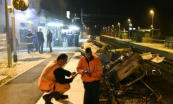 Des agents SNCF et la police près de voitures calcinées sur les voies ferrées devant la gare de Moirans, le 20 octobre 2015