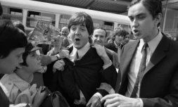 Les membres des Beatles Paul McCartney et George Harrison accueillis par des fans à leur arrivée à l'aéroport d'Orly le 20 juin 1965 avant un concert le soir-même à Paris
