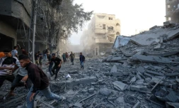 Des personnes courent se mettre à l'abri aprÚs une frappe israélienne qui a visé un bùtiment dans le camp de réfugiés palestiniens de Bureij, dans le centre de la bande de Gaza, le 19 octobre 2025