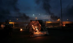 Des débris en feu gisent sur la route après que des partisans de Raila Odinga, candidat à la présidentielle kenyane, ont protesté contre les résultats, à Kisumu, dans l'ouest du Kenya, le 15 août 2022
