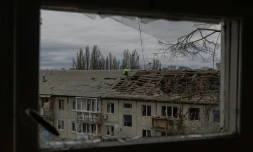 Des ouvriers dégagent les débris du toit d'un immeuble résidentiel fortement endommagé après une frappe de drone russe à Kyiv, le 23 décembre 2025 en Ukraine