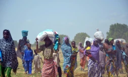 Des femmes et des enfants fuient leurs maisons incendiées par des islamistes de Boko Haram, le 3 juillet 2015 à Zabarmari, près de Maiduguri, au nord-est du Nigeria