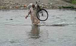 Un homme traverse une rue inondée de Karachi, mégapole du Pakistan où les pluies de mousson ont fait plus de 400 morts en une semaine, le 20 août 2025
