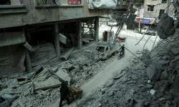 Des Syriens au milieu des destructions dans la ville de Douma, dans la partie rebelle de la Ghouta orientale près de Damas, le 8 mars 2018