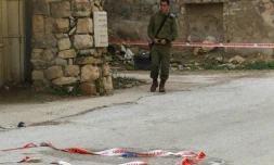 Un militaire israélien surveille le lieu où une jeune Palestinienne a tenté de poignarder un soldat israélien avant d'être abattue, dans la ville d'Hébron, le 13 février 2016
