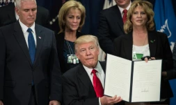 Le président américain Donald Trump montre le décret signé lançant le projet de construction d'un mur à la frontière entre les Etats-Unis et le Mexique, le 25 janvier 2017 à Washington