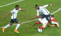 Les Français Patrice Evra et Paul Pogba sur la pelouse à l'état déplorable du stade de Lille, lors du match contre la Suisse, le 19 juin 2016