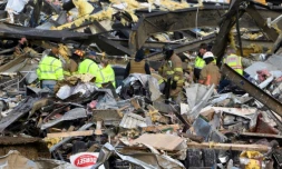 Des secouristes à pied d'oeuvre samedi 11 décembre 2021 dans une usine de bougies de Mayfield