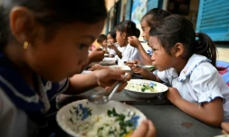 Des écoliers prennent un petit-déjeuner avant d'entrer en classe, le 8 juillet 2022 dans la province de Siem Reap, au Cambodge