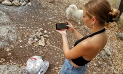 Elishya Ben Meir ramasse des déchets abandonnés, localisés via l'application mobile "Clean Coin" qui la récompense en monnaie virtuelle, près de Haïfa, en Israël, le 20 octobre 2021