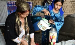 Iodgoroï Makhmalieva (g) et sa petite-fille Mounissa, déplacées climatiques, dans leur nouvelle maison du district de Khourosson, le 26 mars 2024 au Tadjikistan