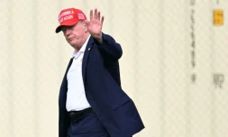Le président Donald Trump salue en direction de la presse à son arrivée à la Maison Blanche, à Washington, le 16 août 2026