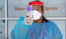 Un agent de santé tient un thermomètre sur un site de test du Covid-19 à St. John's Well Child and Family center à Los Angeles le 24 juillet 2020