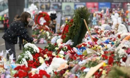 Une femme dépose des fleurs au mémorial pour les victimes de l'attentat du Crocus City Hall, le 29 mars 2024 à Kranogorsk, dans la banlieue de Moscou