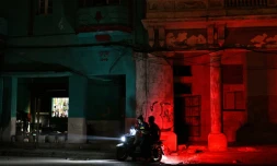 Un homme conduit une moto dans une rue pendant une panne de courant à La Havane, le 16 mars 2026