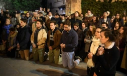 Des fidèles prient devant la cathédrale de Notre-Dame de Paris le 15 avril 2019