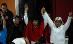 Le leader indigène Leonidas Iza (c), président de la Conaie, et d'autres leaders indigènes lèvent les bras après avoir signé un accord avec le gouvernement mettant fin aux manifestations contre la vie chère, le 30 juin 2022 à Quito, en Equateur