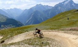 Un cycliste pratique le VTT Alpin, VTT de descente en montagne, le 31 juillet 2017 sur une piste des Deux-Alpes, dans l'Isère