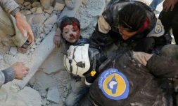 Des Casques blancs de la Défense civile syrienne sauvent un enfant des décombres d'un bâtiment détruit par un bombardement, à Bab al-Nairab, dans le nord d'Alep, le 24 novembre 2016