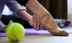 Margarita Chraïner, danseuse du Bolchoï, masse ses pieds avant une séance d'entraßnement dans la chambre de son appartement, le 29 avril 2020 à Moscou