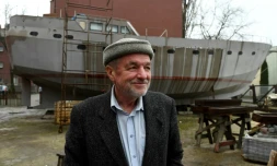 Le capitaine Waldemar Rzeznicki devant la coque d'un voilier construit par des SDF à Varsovie le 27 mars 2017