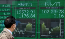 Un passant regarde les cours du yen à Tokyo le 9 mars 2020