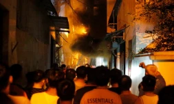 Des habitants observent l'incendie d'un immeuble, Ă HanoĂŻ le 13 septembre 2023