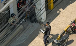 Un policier pointe son arme vers des manifestants à Taunggyi (Birmanie) le 28 février 2021