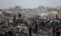 Des Palestiniens, au milieu des décombres sur le chemin côtier de Beit Lahia, dans la bande de Gaza, transportent l'aide alimentaire qu'ils ont pu se procurer le 29 juillet 2025