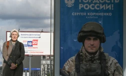 Une passante prÚs d'une affiche faisant la promotion de l'armée russe en Ukraine sur laquelle on peut lire "Fierté de la Russie", à Moscou le 15 septembre 2026