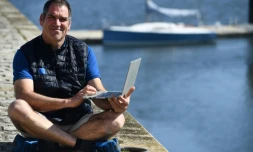 Le skipper français Gildas Morvan pose avec son ordinateur utilisé pour participer à la course virtuelle, le 6 mai 2020 à Landéda (Finistère).