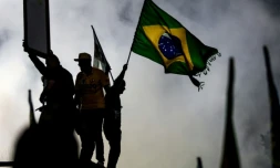 Un partisan du sénateur brésilien de droite et candidat à la présidence, Flavio Bolsonaro, agite un drapeau national lors d'un meeting de campagne à Rio de Janeiro, le 3 octobre 2026