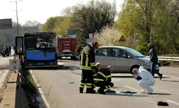 La police scientifique italienne et des pompiers près de la carcasse d'un bus de transport scolaire incendié par son chauffeur le 20 mars 2019 à San Donato Milanese, près de Milan
