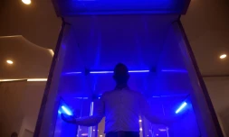 Un homme montre le fonctionnement d'une cabine automatique de désinfection, qui doit aider à lutter contre le coronavirus, à Bogota le 10 août 2020