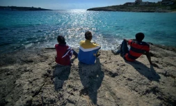 De jeunes migrants regardent la mer depuis l'Ăźle de Lampedusa